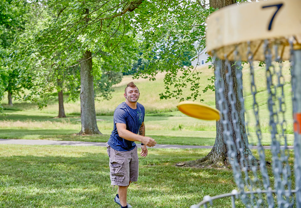Disc golfer throwing to target